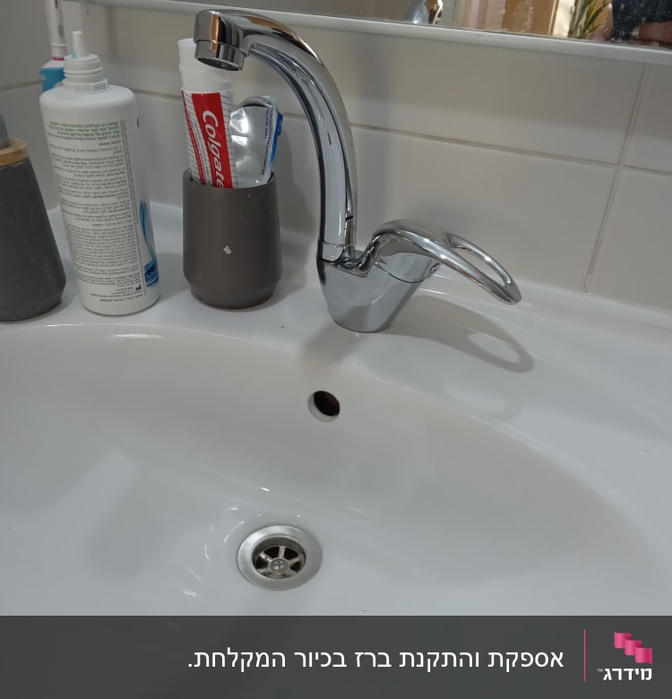 ברז כרום מעל כיור לבן עם ניקוז